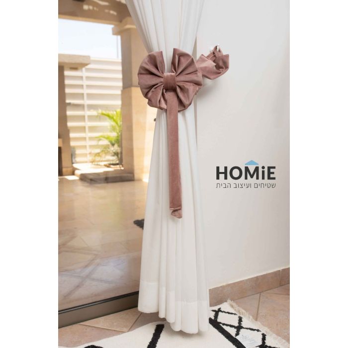 חבק פפיון דקורטיבי קטיפה לוילון בצבע ורוד עתיק. החבק המהודר והיוקרתי המגיע בסגנון הרטרו כפרי ישדרג את מראה הוילון שלכם בכמה רמות ויאסוף אותו בצורה אפקטיבית ונעימה לעין. הוא מיוצר בעבודת יד על ידי אמן מוכשר שהשקיע בו עבודה מרובה. החבק יתאים לסלון, חדר שינה