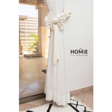 חבק פפיון דקורטיבי קטיפה לוילון בצבע שמנת. החבק המהודר והיוקרתי המגיע בסגנון הרטרו כפרי ישדרג את מראה הוילון שלכם בכמה רמות ויאסוף אותו בצורה אפקטיבית ונעימה לעין. הוא מיוצר בעבודת יד על ידי אמן מוכשר שהשקיע בו עבודה מרובה. החבק יתאים לסלון, חדר שינה, חדר