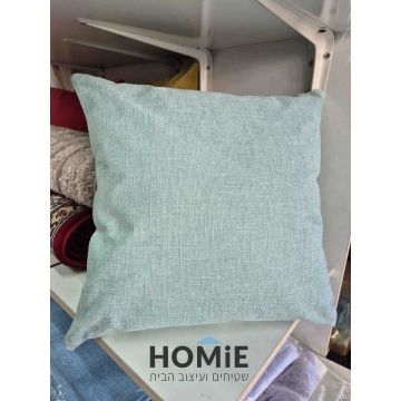 כרית נוי מרובעת בצבע מנטה חלק מונחת על מדף
