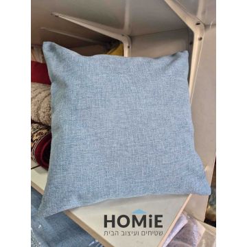 כרית נוי מרובעת בצבע תכלת דמוי פשתן מונחת על מדף